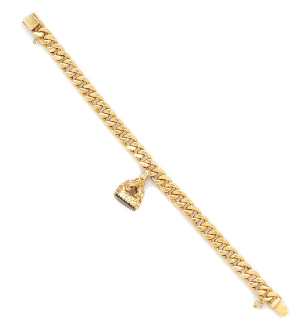 An 18 Karat Yellow Gold and Onyx Charm Bracelet, 13.00: An 18 Karat Yellow Gold and Onyx Charm Bracelet, consisting of a curb link chain measuring approximately 7.40 mm wide suspending one charm containing an onyx plaque measuring 12.40 x 9.65 mm. Stamp: 1