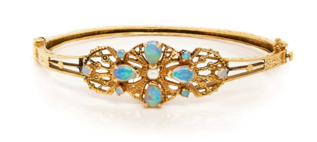A 14 Karat Yellow Gold, Cultured Pearl and Opal Bangle: A 14 Karat Yellow Gold, Cultured Pearl and Opal Bangle Bracelet, containing one pearl measuring approximately 2.95 mm in diameter, surrounded by four pear shape cabochon cut opals measuring approximat