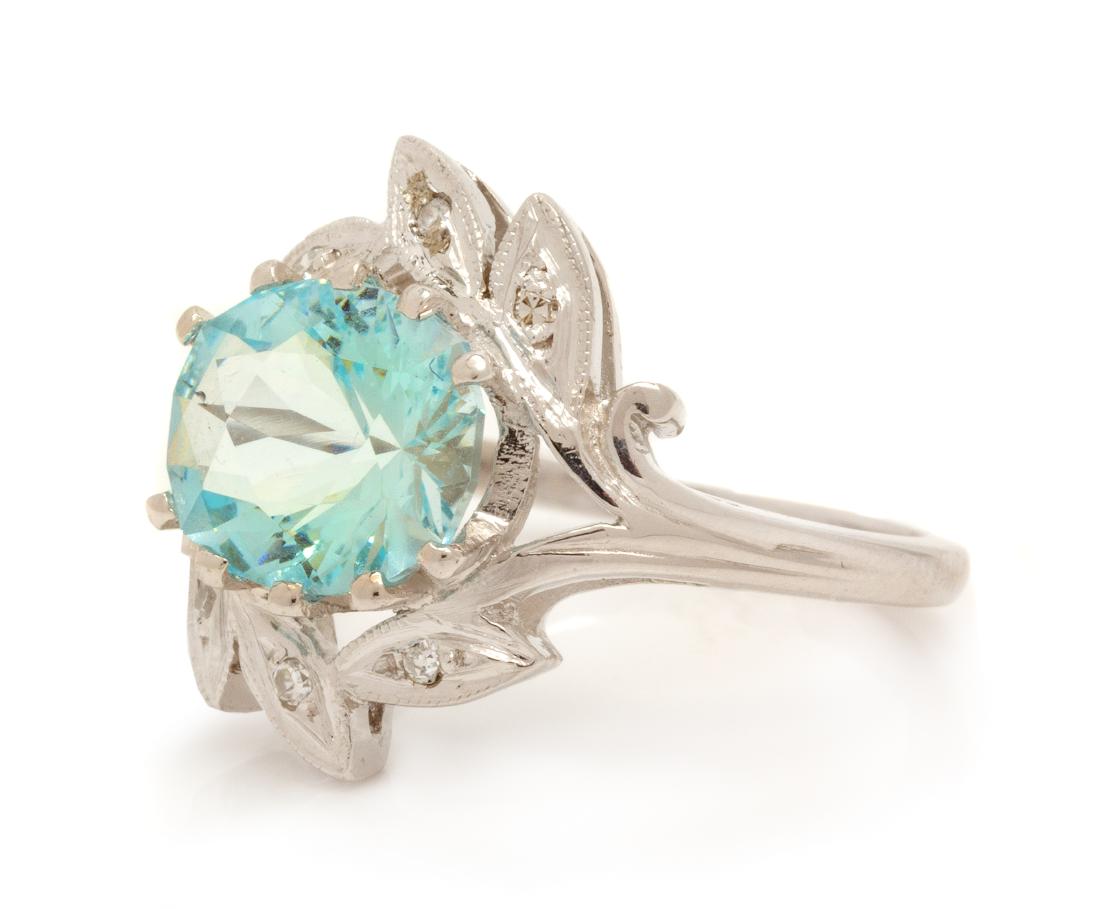 A 14 Karat White Gold, Aquamarine and Diamond Ring,: A 14 Karat White Gold, Aquamarine and Diamond Ring, containing one oval mixed cut aquamarine measuring approximately 9.55 x 8.15 x 6.00 mm and six single cut diamonds. Stamp: 14K LORI. 2.60 dwts. Esti