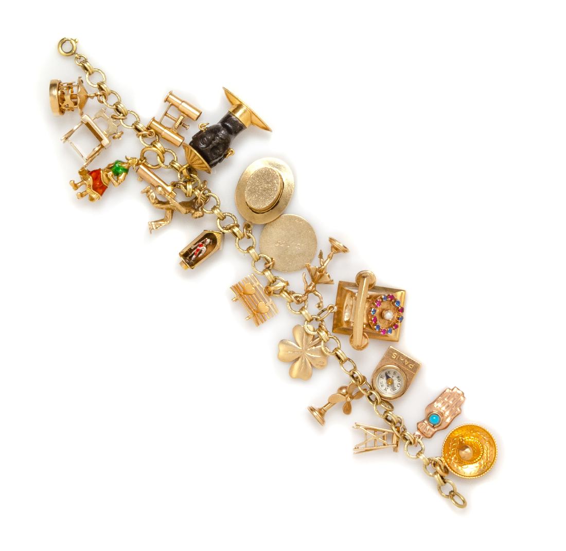 A 14 Karat Yellow Gold Charm Bracelet with 15 Attached: A 14 Karat Yellow Gold Charm Bracelet with 15 Attached Charms, including a carousel charm, a sewing machine charm, a binoculars charm, a Dutch woman charm with red and green enamel, an ebony and gold 