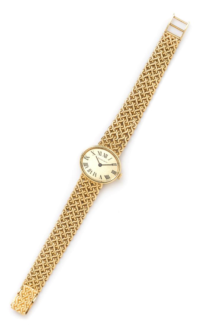 An 18 Karat Yellow Gold Wristwatch, Tiffany & Co.,: An 18 Karat Yellow Gold Wristwatch, Tiffany & Co., 21.00 x 18.00 mm case dimensions, matte gold dial signed TIFFANY & CO, Roman numerals, black pencil hands, snap on case back, 7 jewel quartz movement