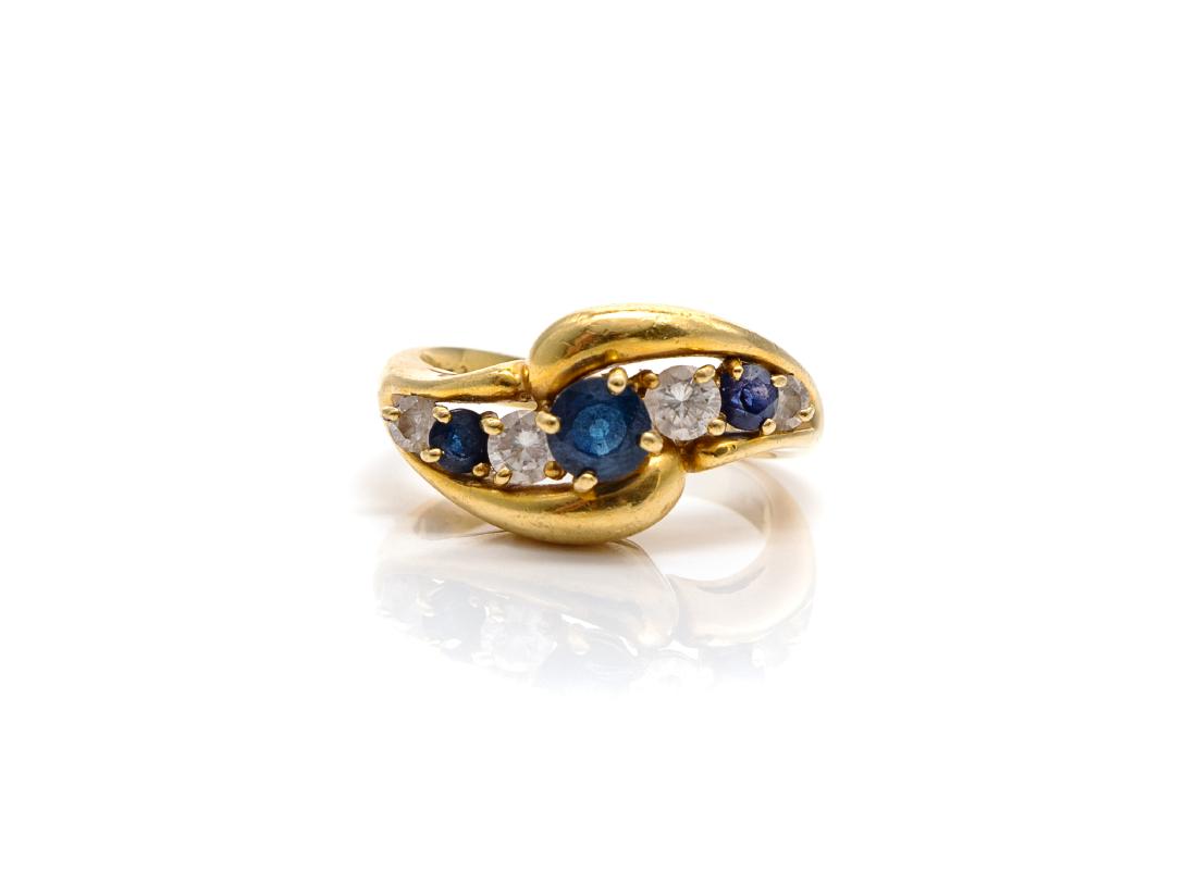 An 18 Karat Yellow Gold, Sapphire and Diamond Ring,: An 18 Karat Yellow Gold, Sapphire and Diamond Ring, Kurt Wayne, containing three round mixed cut sapphires measuring approximately 2.70-4.80 mm in diameter and four round brilliant cut diamonds weighi