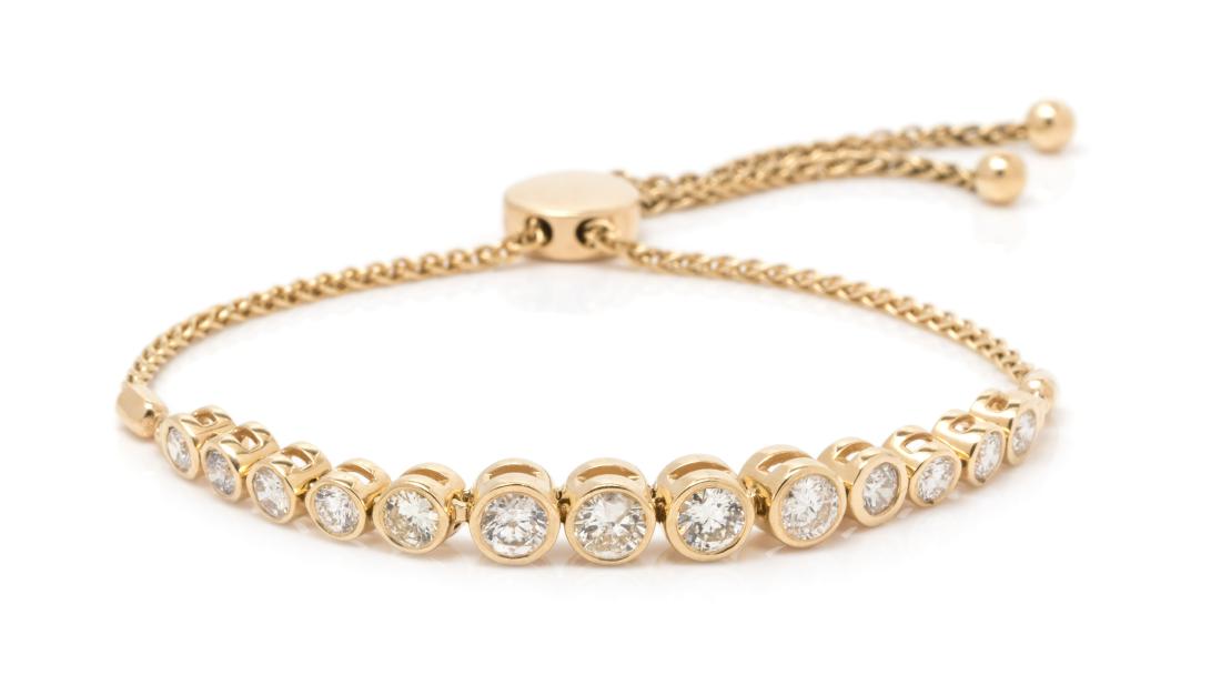 A 14 Karat Yellow Gold and Diamond Bracelet, 6.00 dwts.: A 14 Karat Yellow Gold and Diamond Bracelet, containing 13 round brilliant cut diamonds weighing approximately 2.00 carats total, with adjustable slide clasp. Stamp: 14K. 6.00 dwts. Estimate $1,200-1,