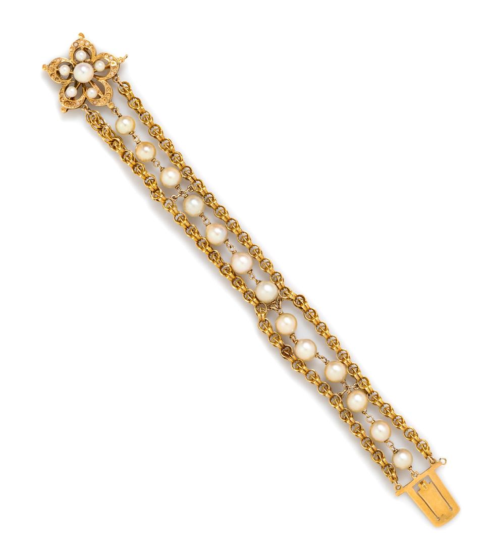 A Yellow Gold and Cultured Pearl Bracelet, 12.40 dwts.: A Yellow Gold and Cultured Pearl Bracelet, containing 13 pearls measuring approximately 6.10-6.50 mm in diameter with fancy link chain on both sides, the floral motif clasp containing six pearls measu