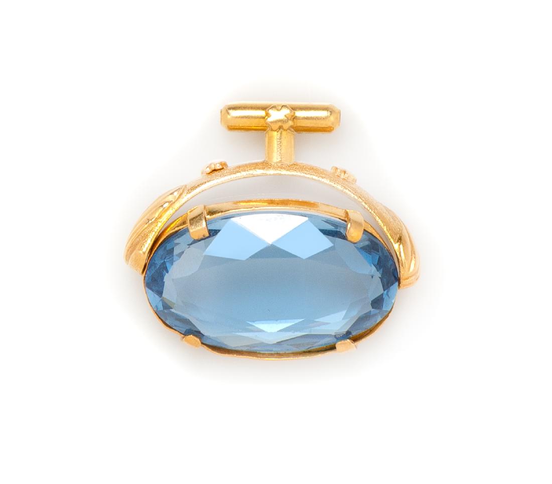 A Yellow Gold and Synthetic Spinel Pendant, 9.50 dwts.: A Yellow Gold and Synthetic Spinel Pendant, containing one oval shape mixed cut synthetic spinel measuring approximately 28.00 x 18.00 x 6.00 mm with a rotating swivel. 9.50 dwts. Estimate $250-350 Pl