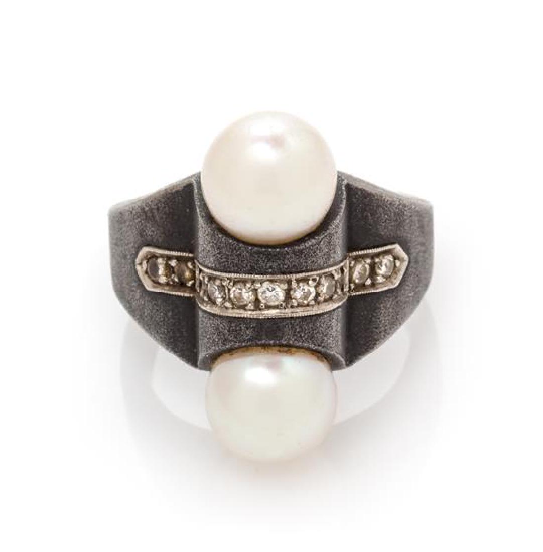 * An Art Moderne Blackened Steel, White Gold and: * An Art Moderne Blackened Steel, White Gold and Cultured Pearl Ring, Marsh & Co., unsigned, containing two pearls measuring approximately 8.25-8.35 mm in diameter, the center of the ring inset with w