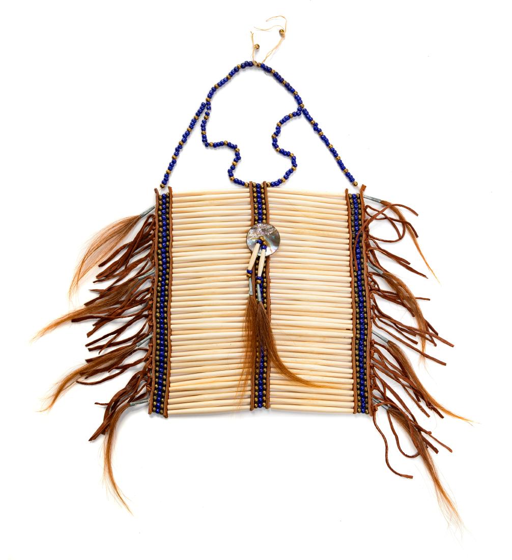 Native American Costume Breast Plate, 1930-80s: Native American Costume Breast Plate, 1930-80s breast plate made of long bone beads with blue and bronze colored bead trim with leather fringe, horse hair tassels, and a center shell pendant. Unlabele
