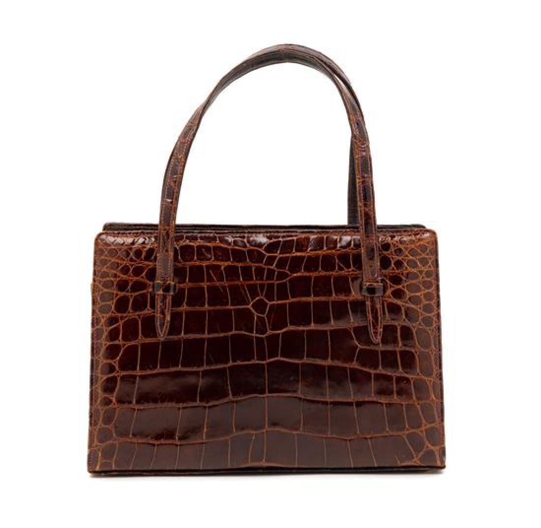 * A Lucille de Paris Brown Crocodile Bag, 1950-70s: * A Lucille de Paris Brown Crocodile Bag, 1950-70s With goldtone clasp, tan leather lining and removable mirror. Estimate $100-200 Property from the Collection of James Lee Soffer, Pittsburgh, Pennsyl