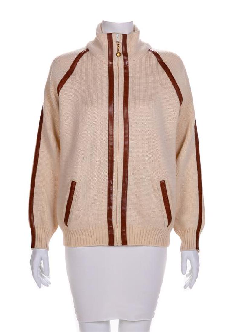 A Celine Cream Zip-Front Wool Sweater, 1970-80s: A Celine Cream Zip-Front Wool Sweater, 1970-80s Cream wool knit trimmed with brown leather and cut with a stand collar, long sleeves and hip pockets. Closed down center front with a separating zip. It