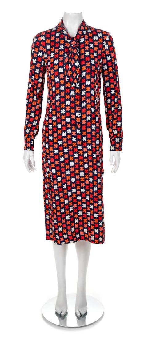 Givenchy Nouvelle Boutique Navy Floral Dress, 1980-90s: Givenchy Nouvelle Boutique Navy Floral Dress, 1980-90s Long sleeves, attached front tie, side pleat detail on skirt, an interior black sheer quarter upper back lining, and a front blue button closure.