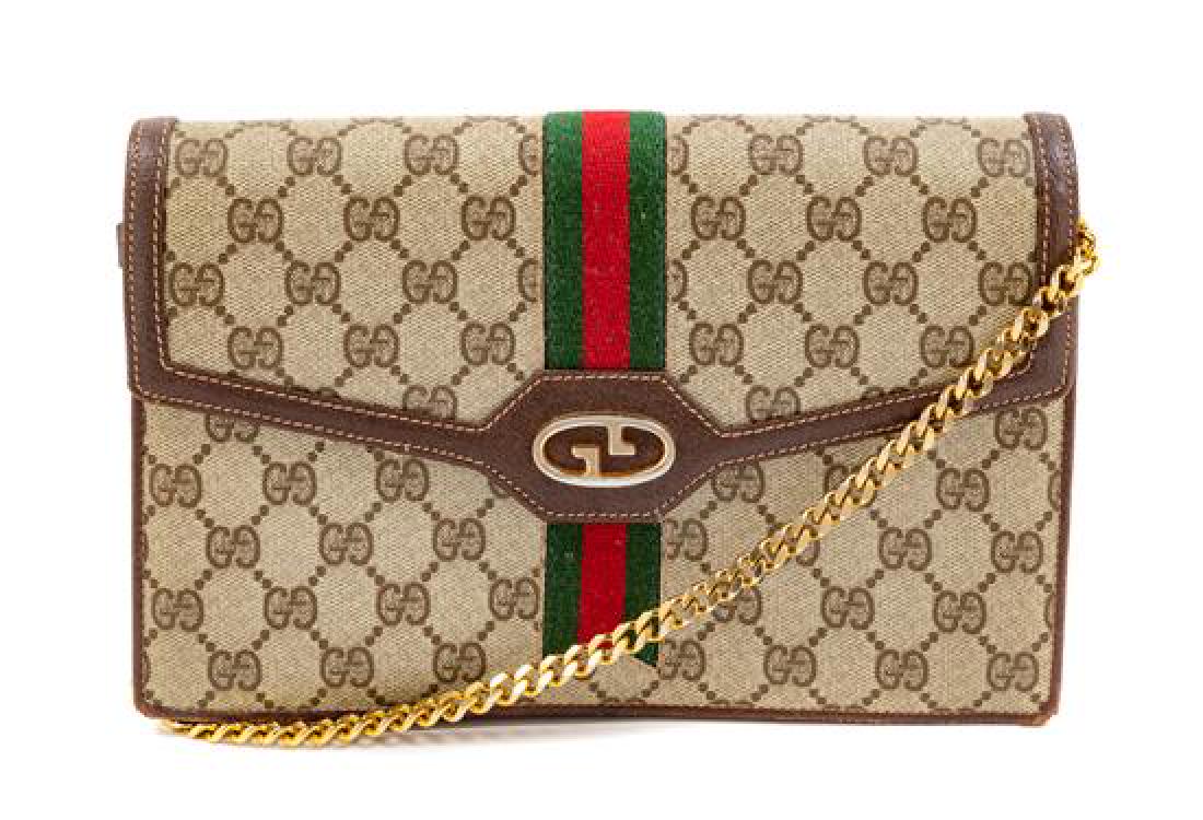 Gucci Signature Purse with Logo, 1990s: Gucci Signature Purse with Logo, 1990s goldtown hardware, brown interior with a zip pocket, chain and leather shoulder strap, front flap with a pin button closure. Together with a dustbag. Stamp: Gucc