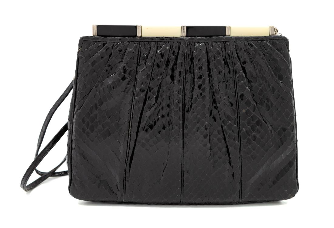 Judith Leiber Black Snakeskin Clutch: Judith Leiber Black Snakeskin Clutch with silvertone hardware, a decorative black and cream bar top push closure, an optional shoulder strap, two exterior slip pockets and one interior compartment wit