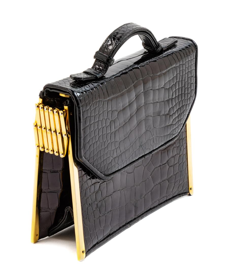 * Judith Leiber Gilt Metal and Black Crocodile Purse: * Judith Leiber Gilt Metal and Black Crocodile Purse Goldtone metal frame and hinge on each side, exterior back slip pocket, interior black leather lining with a slip pocket and a zip pocket, front fl