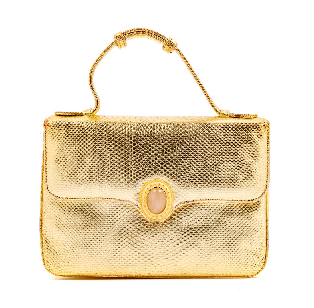 * Judith Leiber Gold Leather Purse: * Judith Leiber Gold Leather Purse Goldtone and pink glass clasp. Pink fabric lining. Includes detachable gold leather strap, mirror and coin purse. Label: Judith Leiber © / New York Estimate $60-80