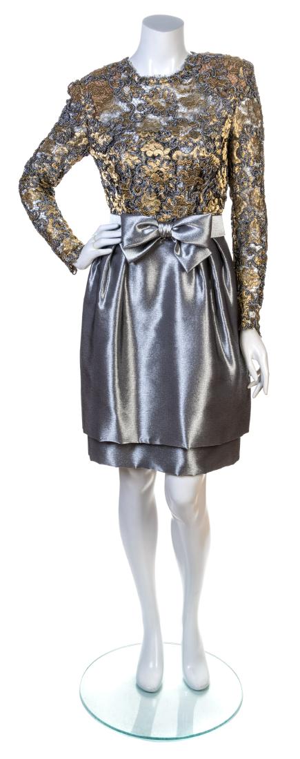 A Stanley Platos/Martin Ross Silver Lame Cocktail: A Stanley Platos/Martin Ross Silver Lame Cocktail Dress, 1980s Heavy silver strapless dress with at two-tier skirt with pleats into the waistband. A gold and silver lace jacket with shoulder pads and 