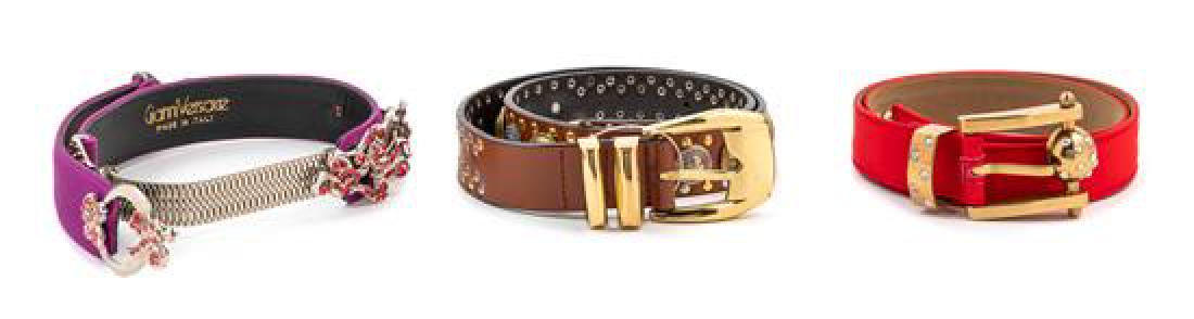 Three Gianni Versace Belts, 1990s: Three Gianni Versace Belts, 1990s Purple: ribbed with silvertone hardware, pink rhinestones and a push pin closure. Red: ribbed with goldtone hardware, buckle with clear rhinestones. Brown: leather wi
