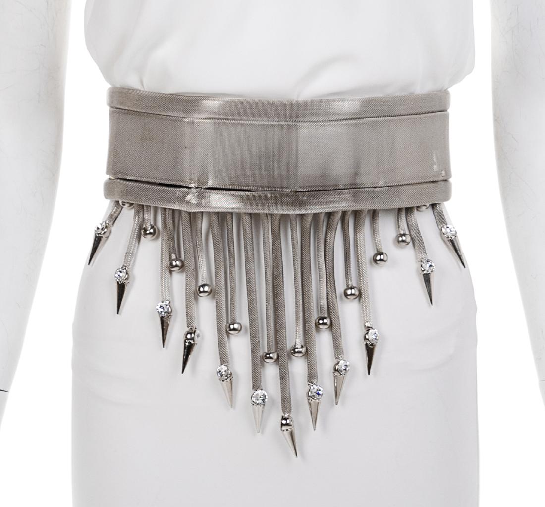 Silvertone Mesh Belt with Mesh Fringe, 1990s: Silvertone Mesh Belt with Mesh Fringe, 1990s Unstamped Attributed to Gianni Versace Estimate $100-200 One fringe is broken. Clasp that holds metal bar to mesh belt is loose. The stated overall conditi