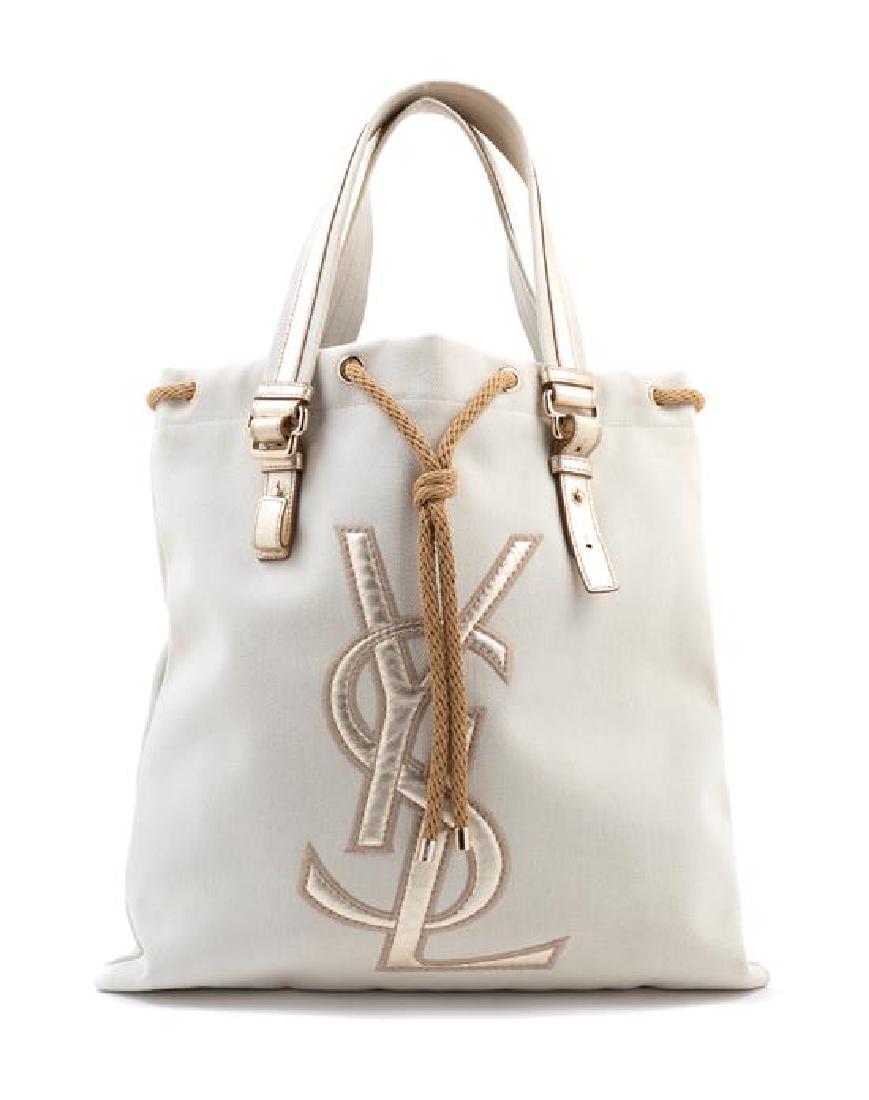 Yves Saint Laurent Cream Canvas Tote, 1990-2000s: Yves Saint Laurent Cream Canvas Tote, 1990-2000s goldtone hardware, a front gold leather YSL, black lining with a zip pocket, adjustable double canvas and gold leather shoulder strap. Stamp: Yves Sain
