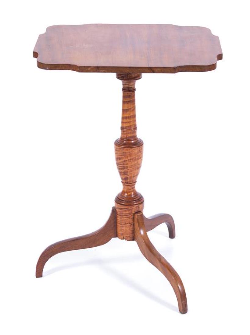 An American Tiger Maple and Maple Tilt Top Tripod Table: An American Tiger Maple and Maple Tilt Top Tripod Table 19th century having a shaped top raised on an urn-form standard. Height 28 x width 19 1/2 x depth 17 inches. Estimate $500-700 The top is not ti