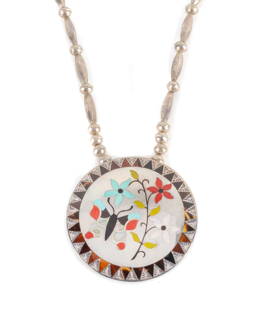 Gary and Serena Banteah Length 12 inches; diameter of: Gary and Serena Banteah Length 12 inches; diameter of pendant 3 inches. (Zuni, 20th Century) flush inlay butterfly pendant, inlaid with turquoise, coral and mother-of-pearl on a silver bead chain, sta