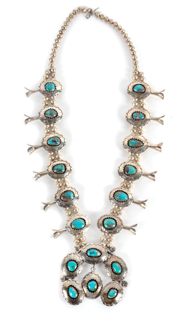 Southwestern Silver and Turquoise Squash Blossom: Southwestern Silver and Turquoise Squash Blossom Necklace Length 27 inches having ten shadow box form blossoms, each with turquoise center stone, and matching naja central hanging pendant
