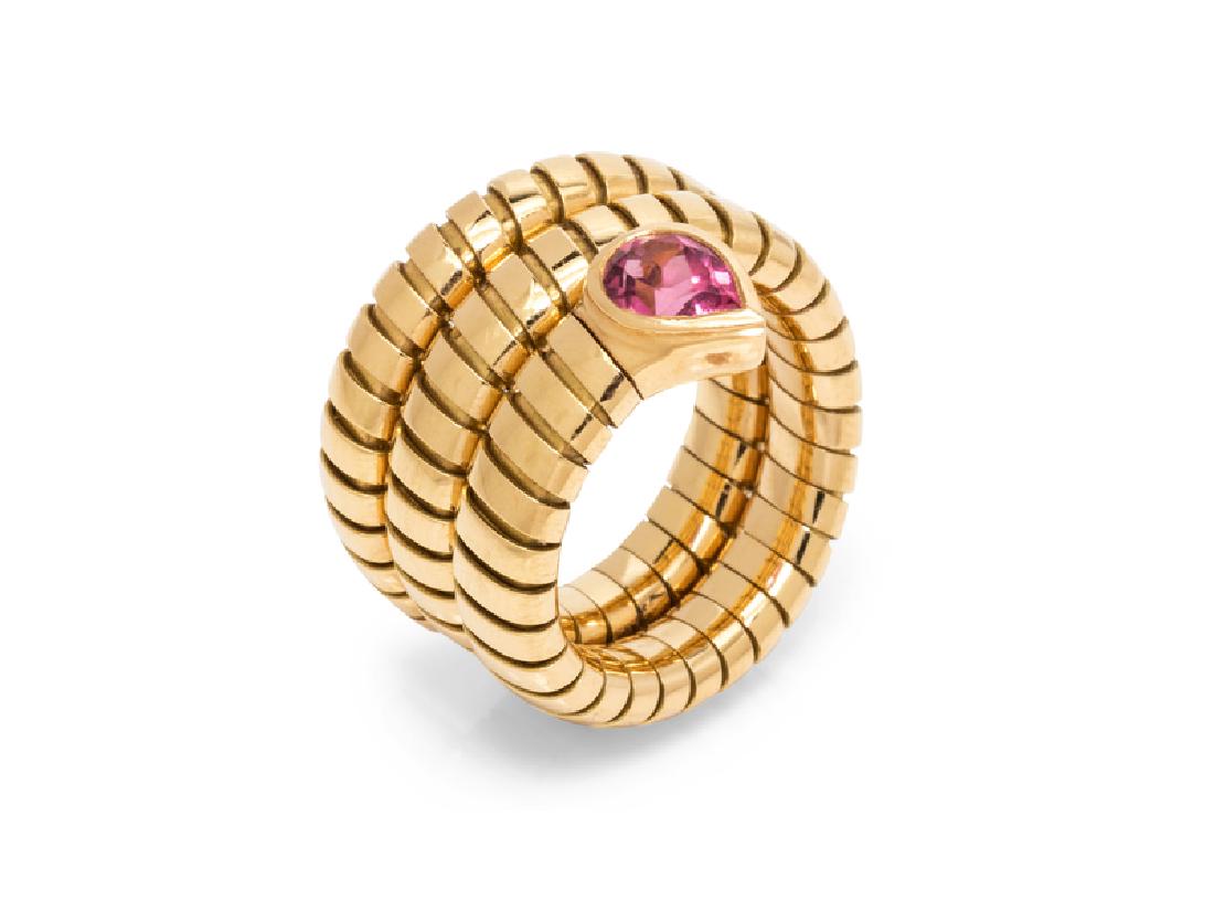 An 18 Karat Yellow Gold and Pink Tourmaline 'Serpenti': consisting of a flexible tubogas style coiled ring containing one pear shape mixed cut pink tourmaline measuring approximately 6.50 x 4.45 x 3.75 mm. Stamp: BVLGARI (Italian hallmark) 750. 9.50 dwts.