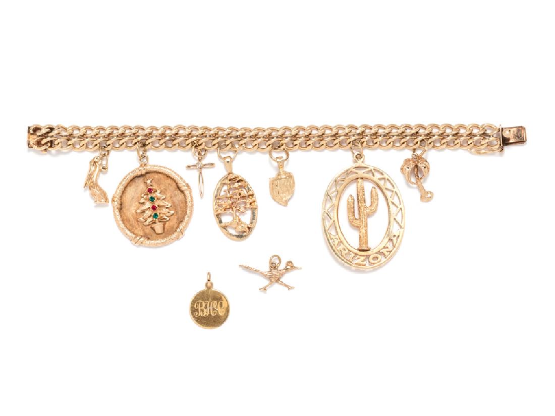 A Yellow Gold Charm Bracelet,: consisting of a 14 karat double curb link bracelet suspending seven charms, including a pelican charm with articulated bill, a 14 karat Christmas tree charm containing four colored gemstones, a 14 kar