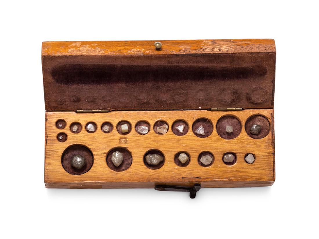 A Vintage Case of Rough Diamonds,: consisting of a fitted wooden box containing one single cut diamond and 18 rough diamonds of various shape and size.