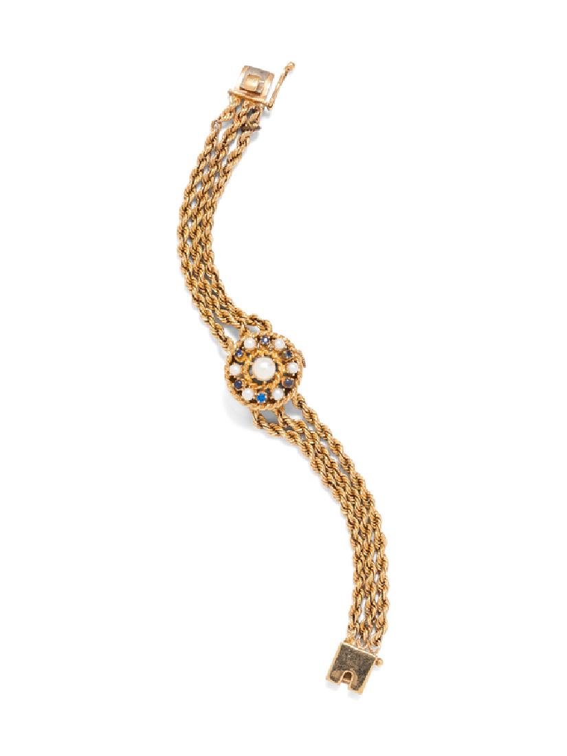 A 14 Karat Yellow Gold, Sapphire, Synthetic Sapphire: the hinged cover containing six pearls and six synthetic and natural sapphires, matte silvered dial, applied gold dot and triangle numerals, gold lozenge hands, snap on case back, 17 jewel movement si