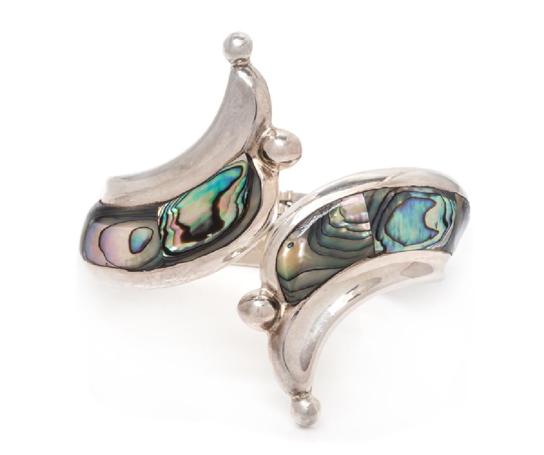 A Sterling Silver and Abalone Clamper Bracelet, Taxco,: consisting of a bypass design with abalone plaque inlay, center opening with hinged back. Stamp: TH-90 MEXICO 925. 42.20 dwts.
