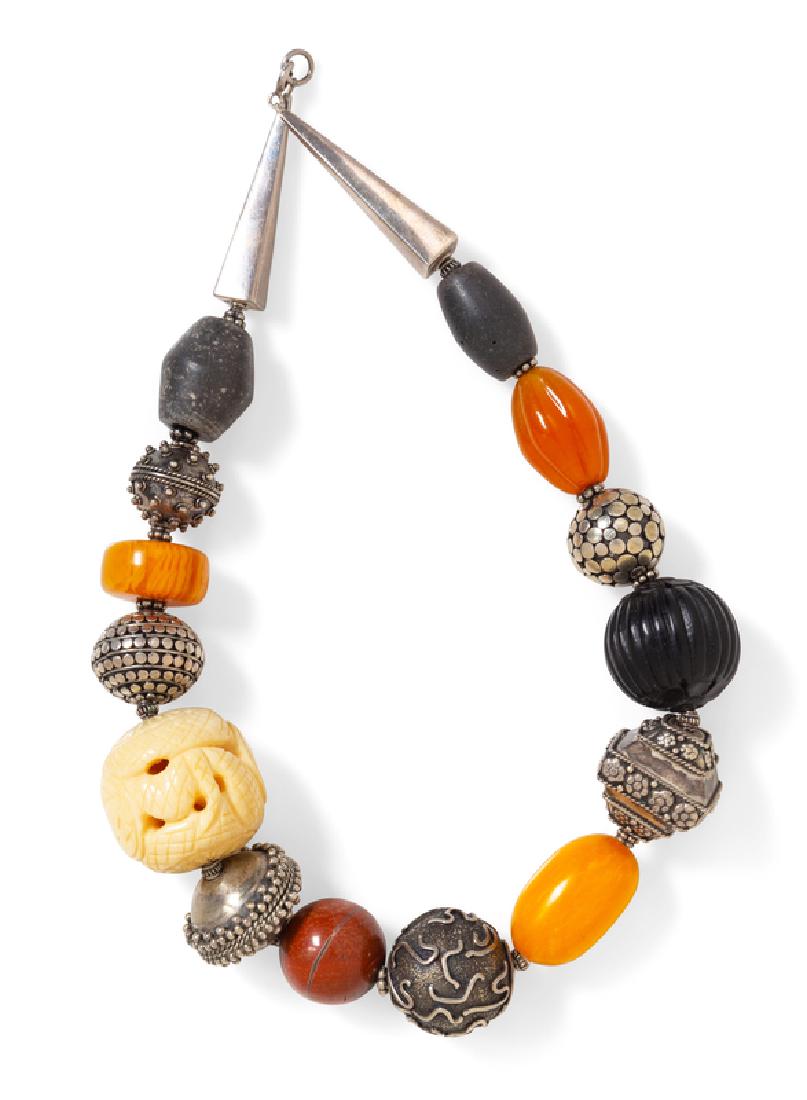 A Sterling Silver, Hardstone, Glass and Bakelite Bead: consisting of a necklace containing one round carved white bead measuring approximately 30.00 mm in diameter, two bakelite beads, one ribbed glass bead, one carved ribbed resin bead, one round jasper 