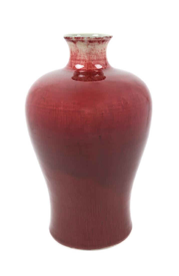 A Chinese Sang-de-Boeuf Glazed Porcelain Vase, Meiping: A Chinese Sang-de-Boeuf Glazed Porcelain Vase, Meiping 19TH CENTURY the tapering baluster body rising from a recessed base to a short narrow waisted neck with everted rim, the base drilled. 34 height 