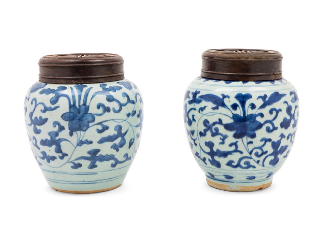 A Pair of Chinese Blue and White Porcelain Ginger Jars: A Pair of Chinese Blue and White Porcelain Ginger Jars 20TH CENTURY each of ovoid form with fitted wood cover, painted with curling floral vines. Each: 18 height centimeters,Each: 7 height inches