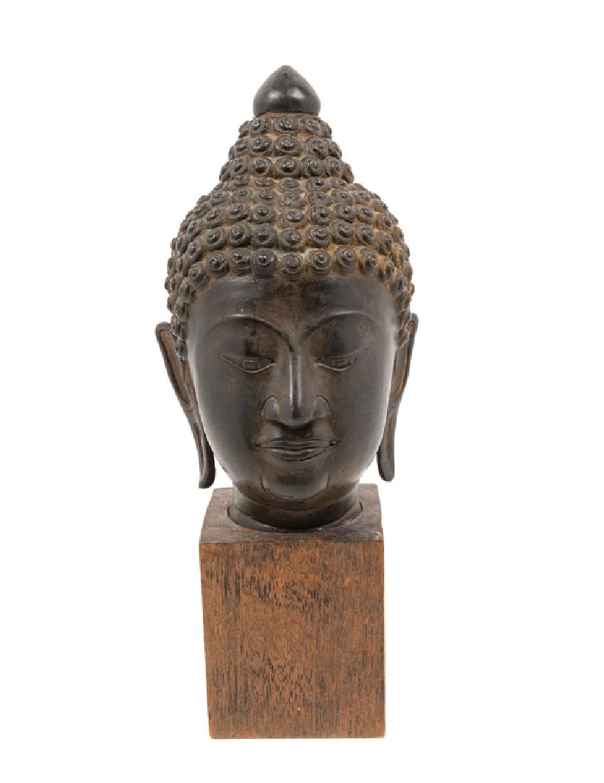 A Thai Bronze Head of Buddha with tight curled hair,: A Thai Bronze Head of Buddha with tight curled hair, elongated ear-lobes and a raised ushnisa, the face with serene expression, downcast eyes, and arched eyebrows. Property from the Collection of a G