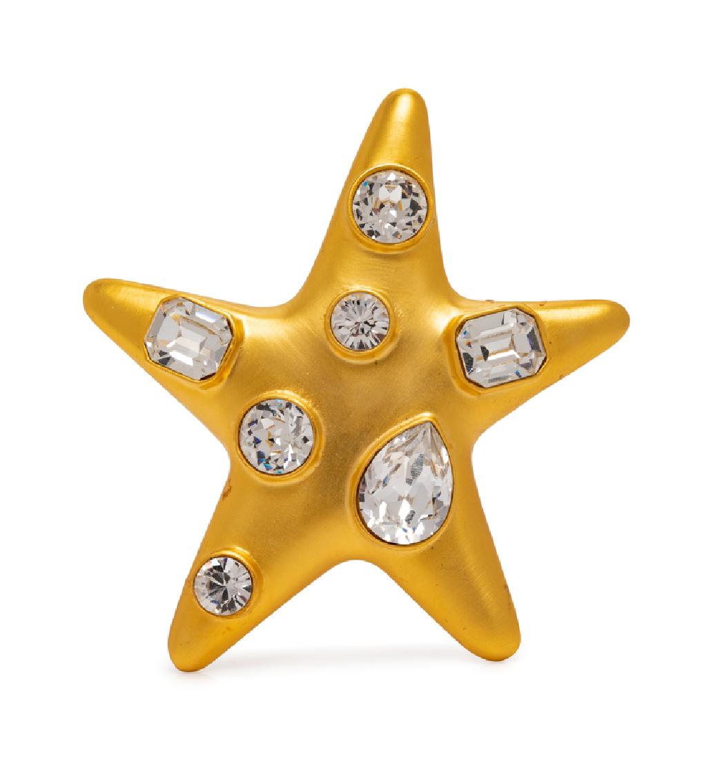 Kenneth Lane Brooch, 1980-90s: Kenneth Lane Brooch, 1980-90s Star-shaped goldtone brooch inset with faceted rhinestones in a variety of shapes with back pin and safety clasp. Size: 3.25" x 3.5". Stamped: Kenneth Lane Condition: