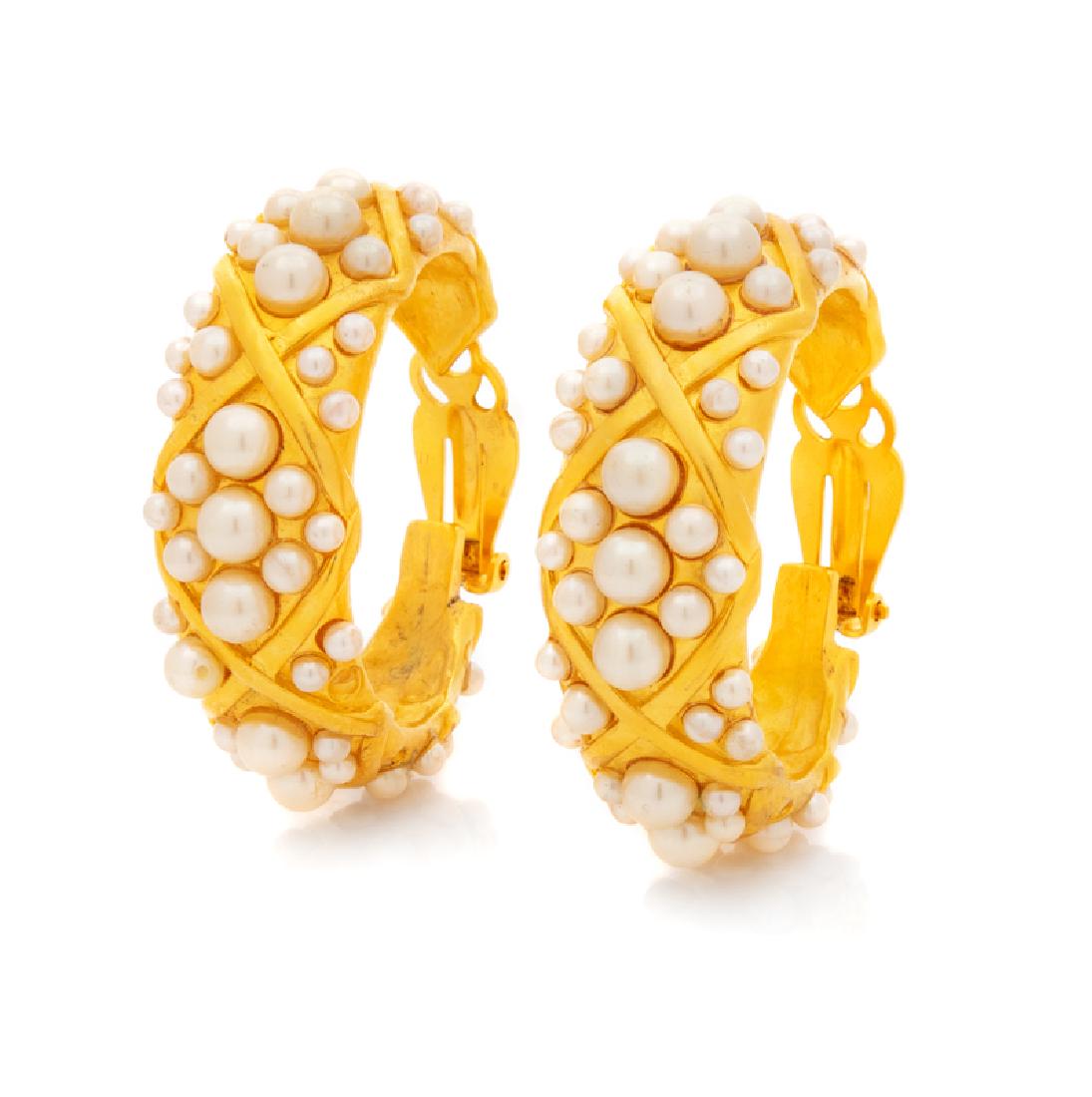 Karl Lagerfeld Earrings, 1980s: Karl Lagerfeld Earrings, 1980s Goldtone hoops with crisscross shape and set with small faux pearls. Diameter: 1.5" x 1.5"; Width: 1.75". Stamp: KL. Condition: Overall very good condition. One hoop i