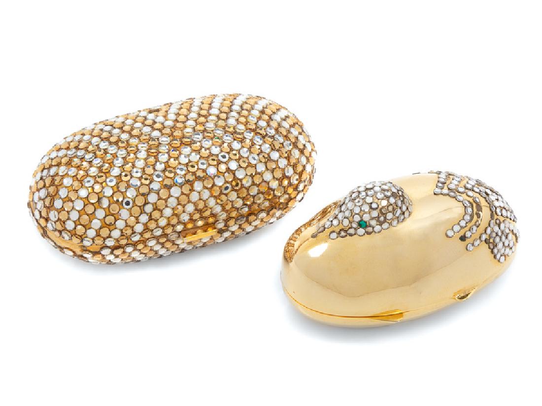 Two Judith Leiber Pill Boxes, 1980-90s: Two Judith Leiber Pill Boxes, 1980-90s The first: Duck-shaped goldtone box with hinge and trimmed with clear crystals. Size: 2.25"L x 1.25" W x 1.25" H. Together with a small leather pouch. Stamp: J