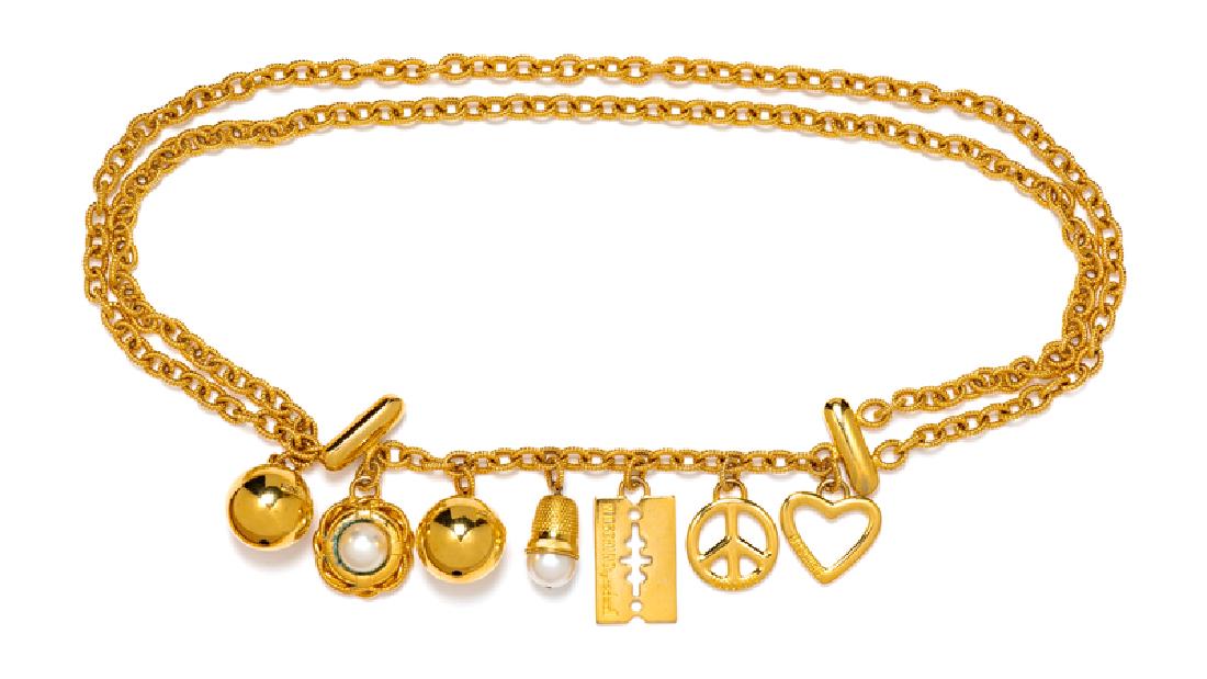 Moschino Charm Chain Belt, 1980-90s: Moschino Charm Chain Belt, 1980-90s Goldtone chain belt featuring charms in shape of a ball, heart, peace sign, razor blade, thimble and life preserver. The life preserver and the thimble Each charm,