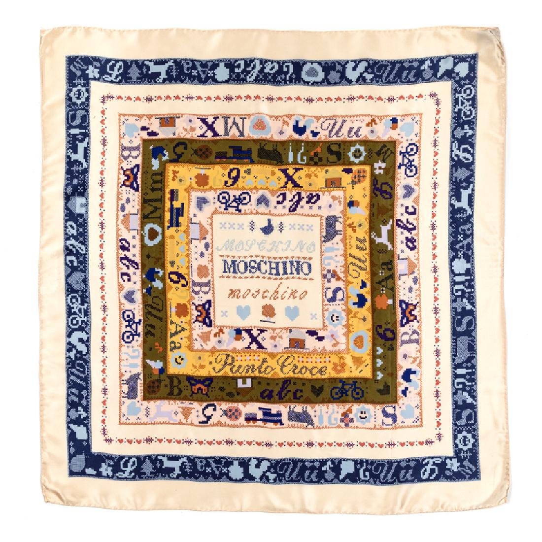 Moschino Scarf, 1990s: Moschino Scarf, 1990s Off-white silk satin scarf printed with a square pattern inspired by cross-stitch, featuring 'Moschino' in the center in three 'fonts'. Labelled within the print and on woven