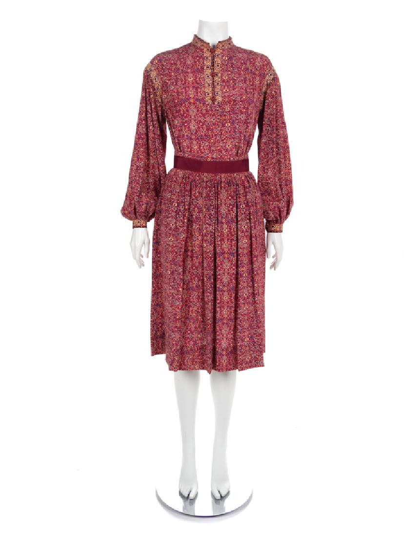Ungaro Ensemble, 1970-80s: Ungaro Ensemble, 1970-80s Blouse and skirt in red printed with a floral pattern in blue, white, yellow and red. The blouse is a pullover style with a stand collar, long sleeves gathered into a thin cu