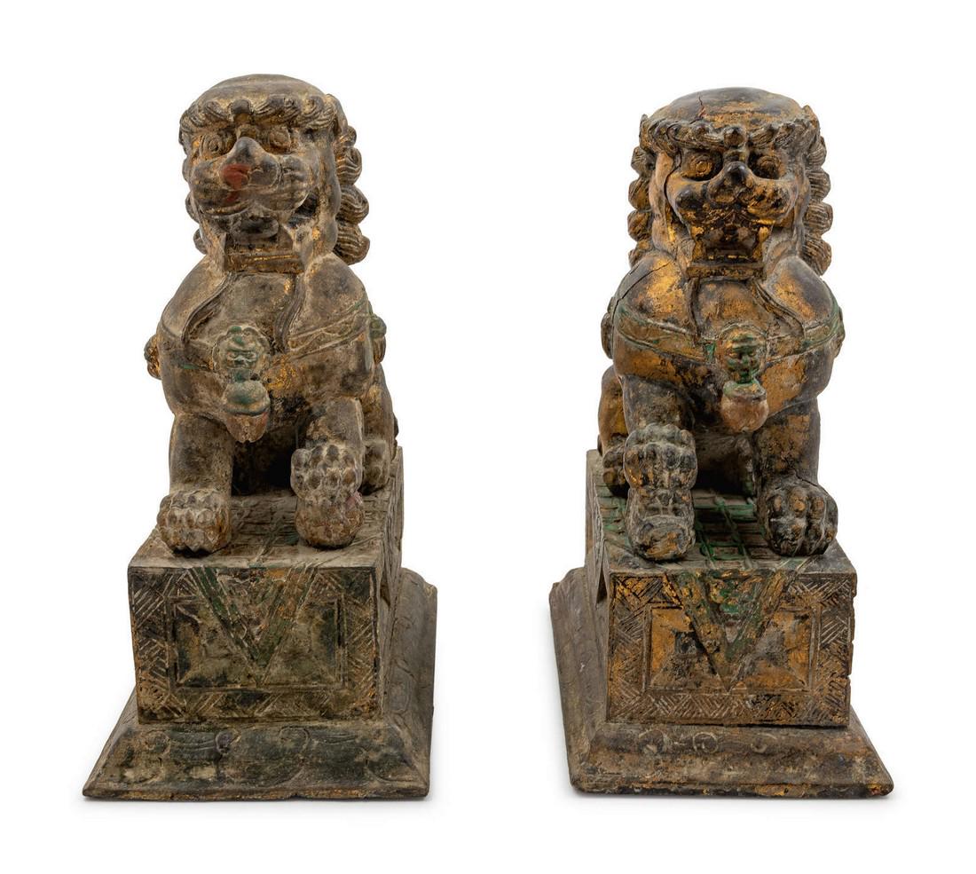 A Pair of Carved Wood Fu Lions LATE 20TH CENTU: A Pair of Carved Wood Fu Lions LATE 20TH CENTURY each set on a rectangular pedestal. Height 15 x width 10 inches. Origin: Property from the Collection of James Flynn and Bill Wiley, Chicago, Illinois