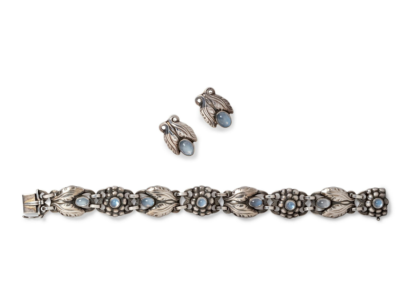 A Sterling Silver and Moonstone Demi-Parure, Georg: A Sterling Silver and Moonstone Demi-Parure, Georg Jensen, consisting of a bracelet containing eight floral motif links and four round and four oval shape cabochon cut moonstones, together with a pair