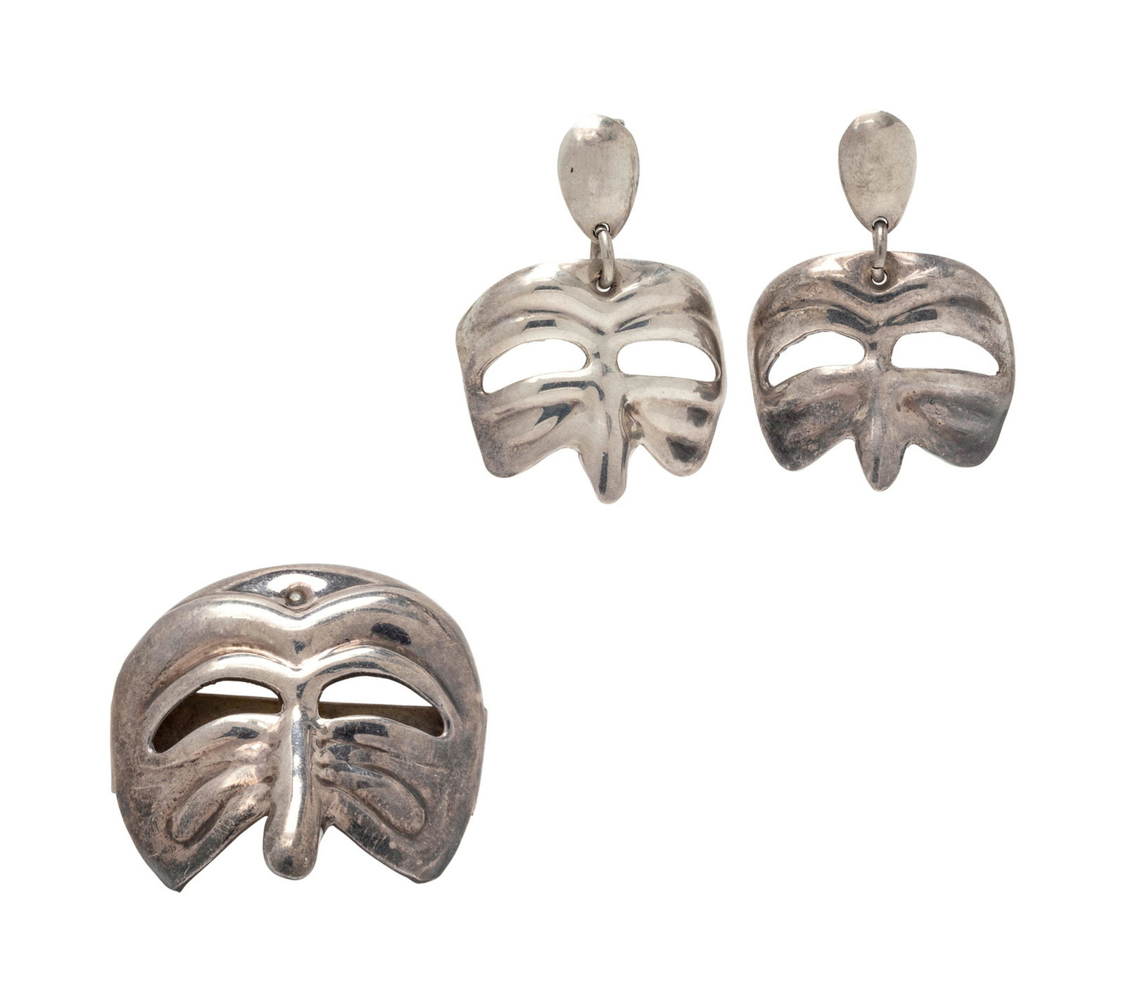 A Sterling Silver Demi-Parure, Mexican,: A Sterling Silver Demi-Parure, Mexican, consisting of a brooch and earrings in the black death mask style. Stamp: TC-151 925 MEXICO. Stamp: TC-150 925 MEXICO. 19.80 dwts.
