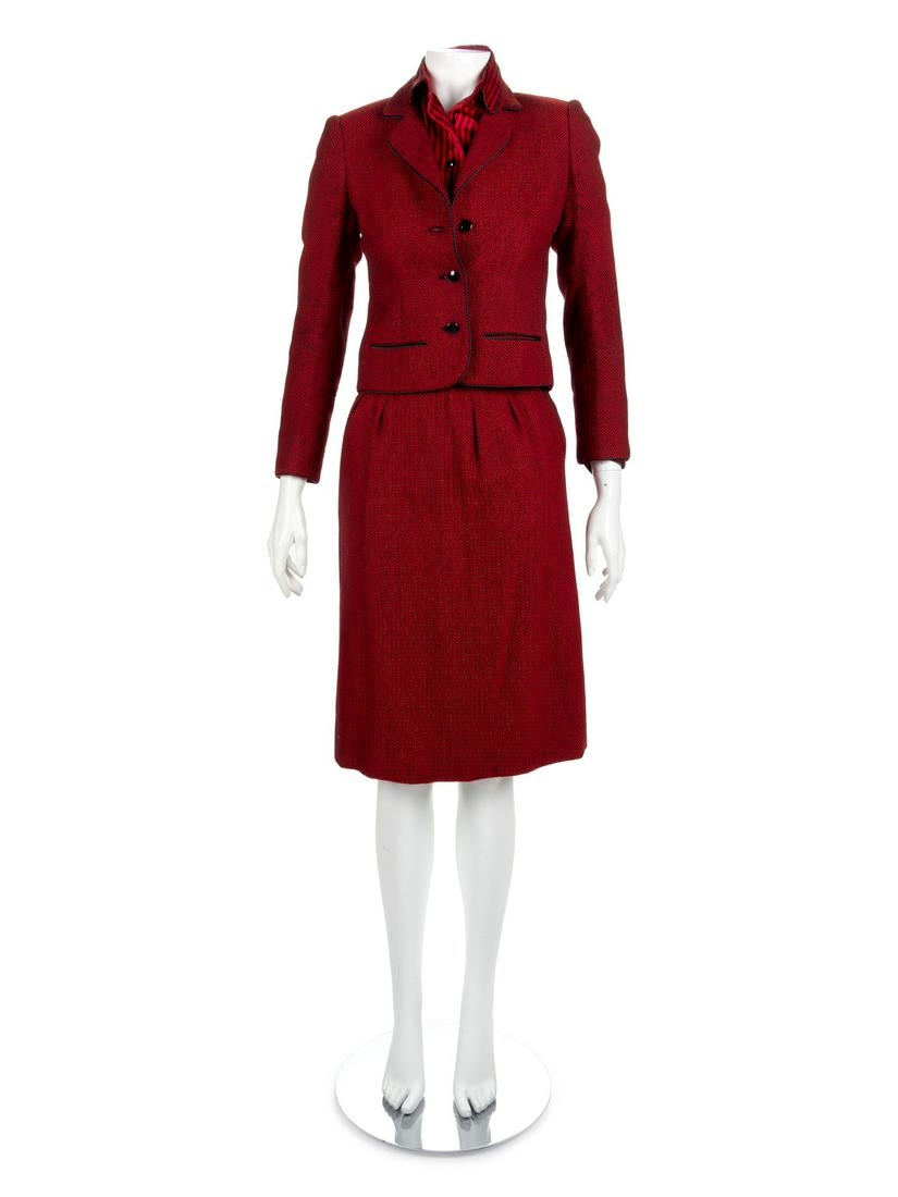 A Nina Ricci Red Tweed Wool Skirt Suit, 1980s Size 36.: A Nina Ricci Red Tweed Wool Skirt Suit, 1980s A Nina Ricci red tweel wool skirt suit consisting of a red button up jacket with two front pockets and black trim and a matching skirt. Paired with a red