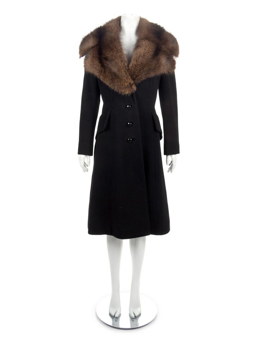 Black Wool Coat with Fur Collar, 1990s: Black Wool Coat with Fur Collar, 1990s Black wool coat with large notched collar of brown fur, long sleeves, center front button closure and flapped pockets over the hips. Approximate Flat Measureme