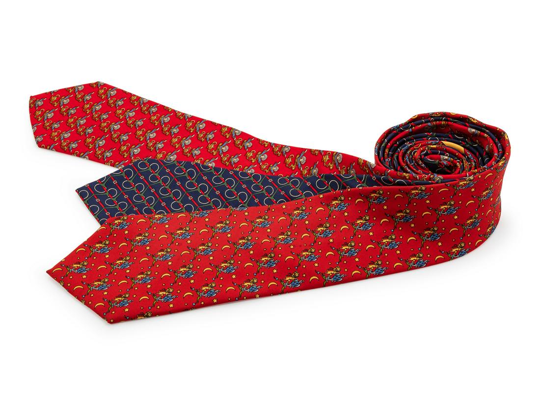 Two Salvatore Ferragamo Silk Ties and One Gucci Silk: Two Salvatore Ferragamo Silk Ties and One Gucci Silk Tie, the first; red with genie and lamp motif, the second; red with moon, lion, and crest motif, the third; navy with buckle and horse bit motif.