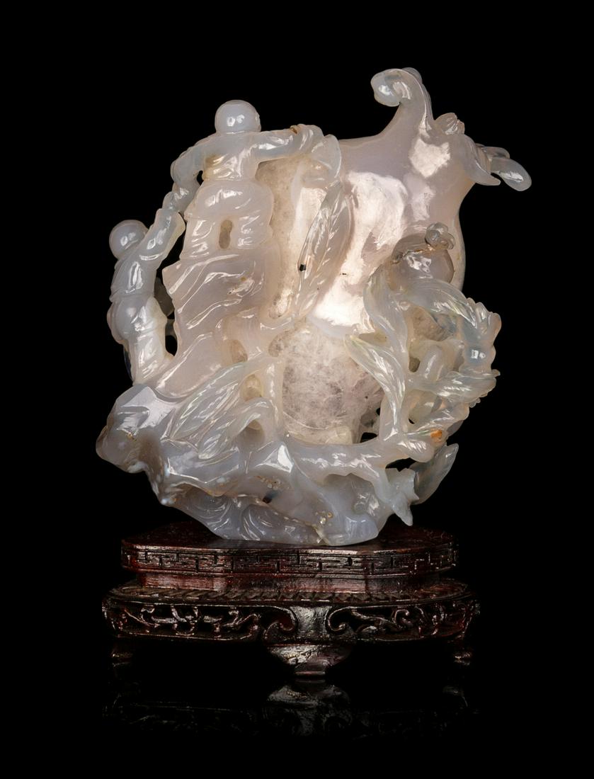 A Chinese Carved 'Boy and Pomegranate' Group Height 5: A Chinese Carved 'Boy and Pomegranate' Group 20TH CENTURY depicting two boys climing onto a large fruiting pomegranate, raised on a later hardwood stand. Height 5 in., 13 cm.