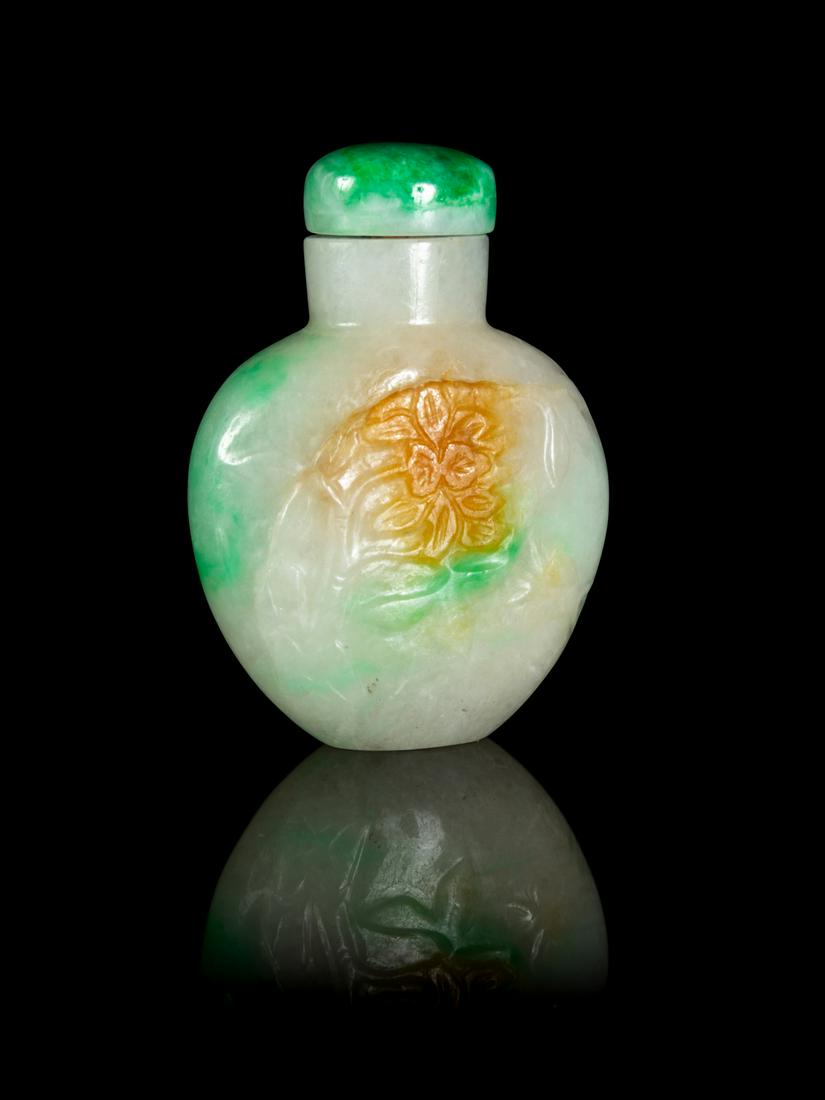 A Chinese Apple Green, Celadon and Russet Jadeite Snuff: A Chinese Apple Green, Celadon and Russet Jadeite Snuff Bottle LATE 19TH/20TH CENTURY of flattened flask form, the front carved in low relief with floral decoration, green jadeite stopper. Height 2 