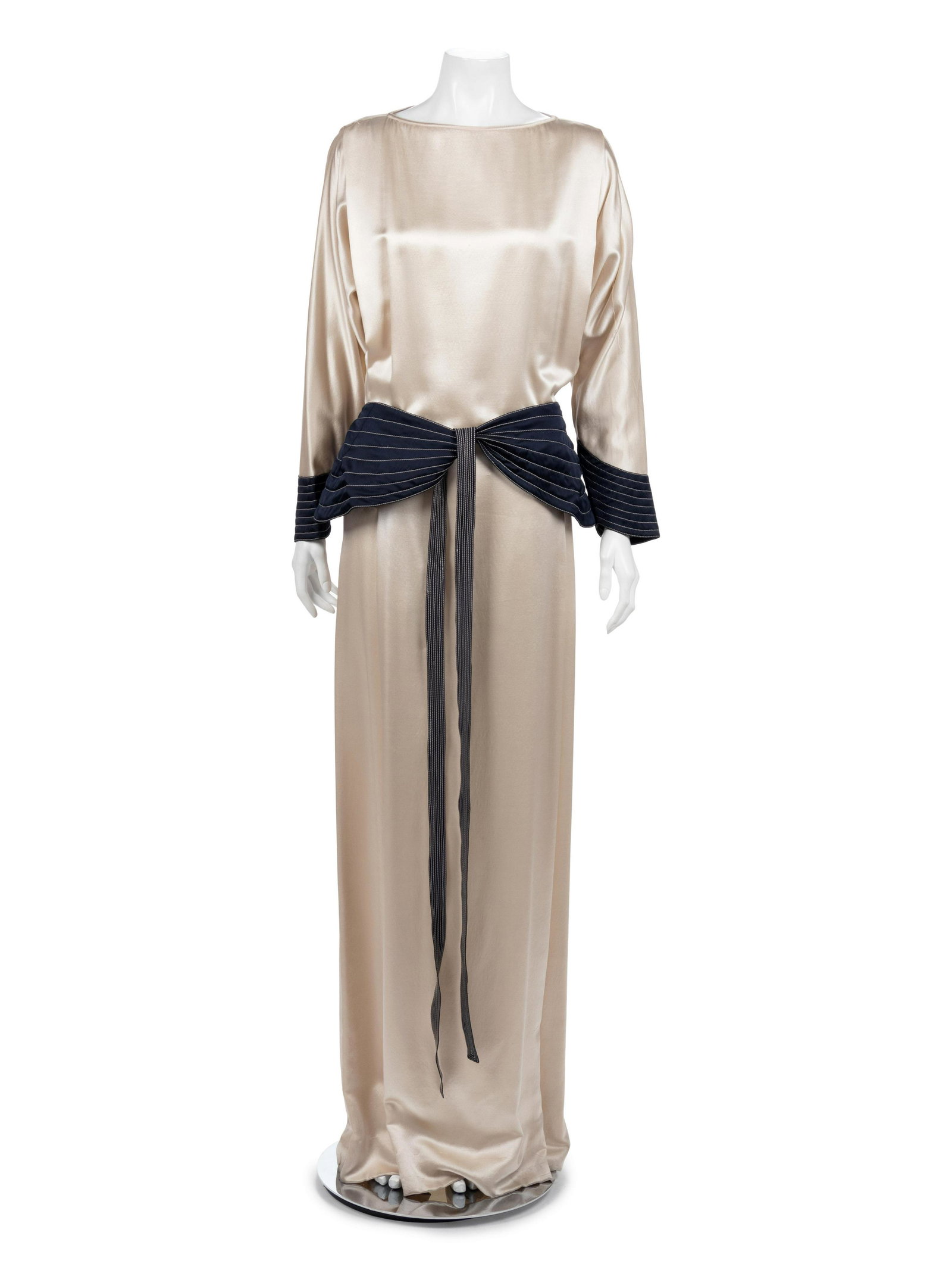 Geoffrey Beene Dress, 1970s: Geoffrey Beene Dress, 1970s Ivory silk satin evening dress with bateau neck, pleat at shoulder seam, dolman sleeves, navy satin with contrasting white quilting curved cuff and front-tying curved hip b