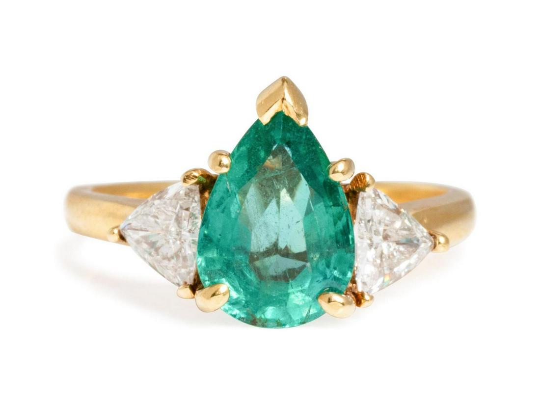 An 18 Karat Yellow Gold, Emerald and Diamond Ring,: An 18 Karat Yellow Gold, Emerald and Diamond Ring, containing one pear shape emerald measuring approximately 9.20 x 6.75 x 4.25 mm and two triangular brilliant cut diamonds weighing approximately 0.50